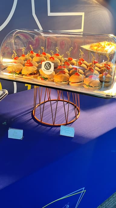 Mini sliders served under a clear dome on a copper stand