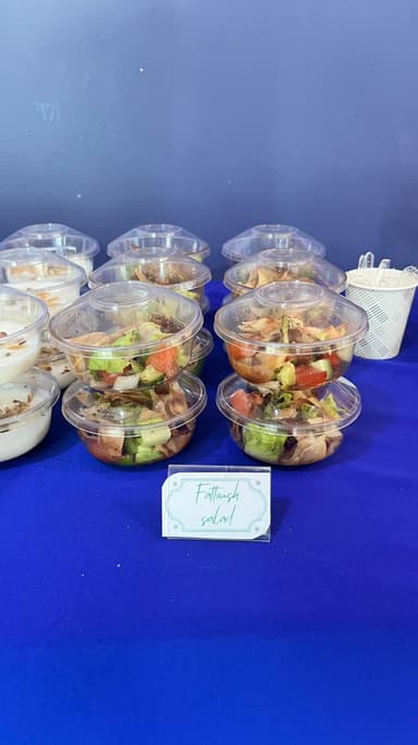 Individual garden salad cups on a buffet table