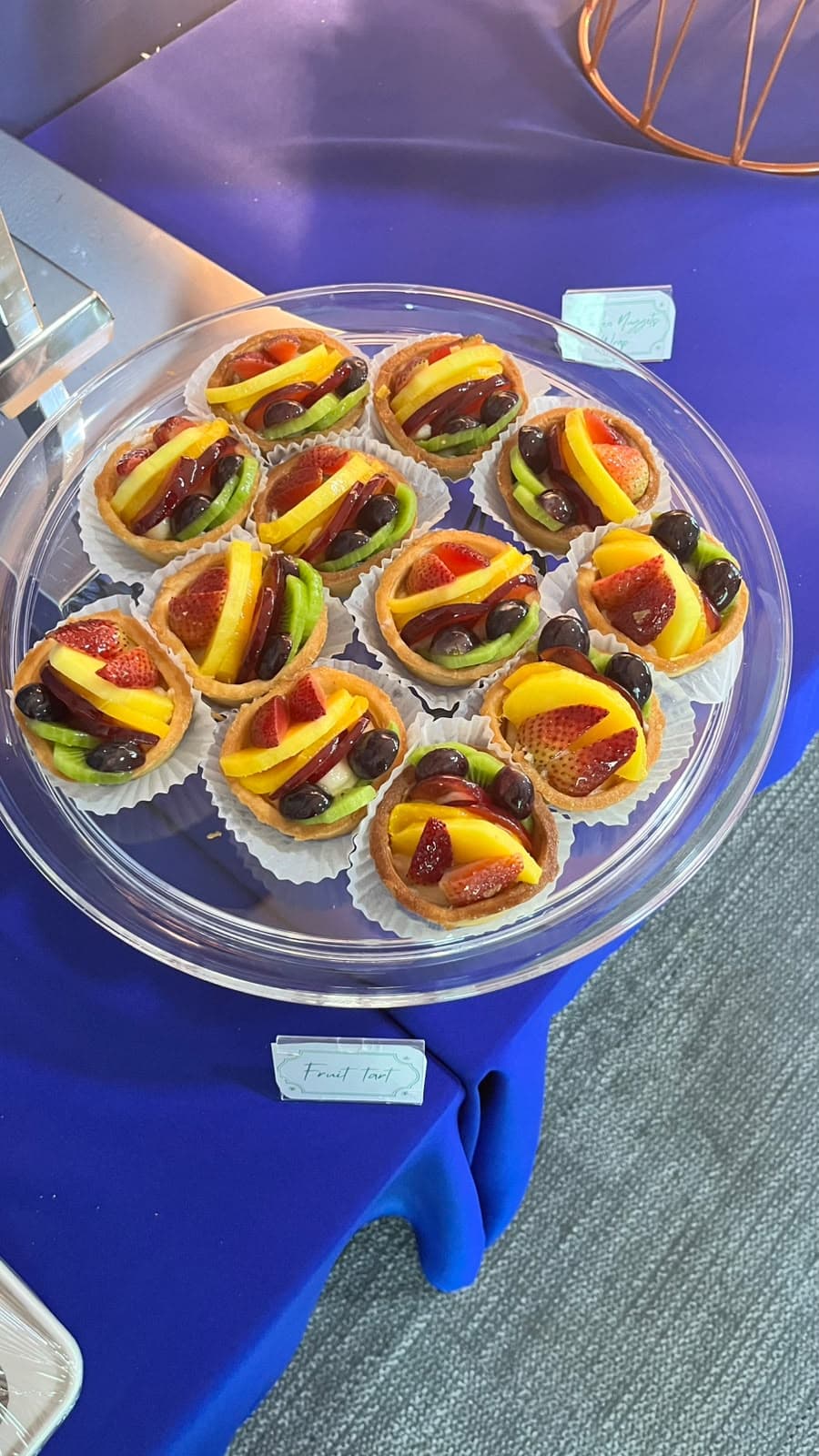 Fresh fruit tarts with strawberry, kiwi and mango on a catering platter