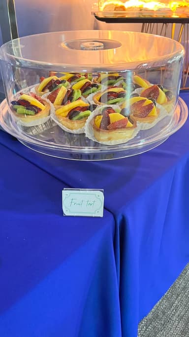 Fruit tarts under a clear cake dome