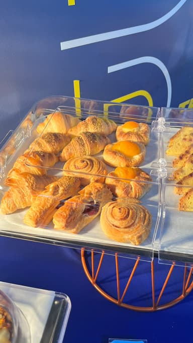Butter croissants and cinnamon rolls under a buffet dome