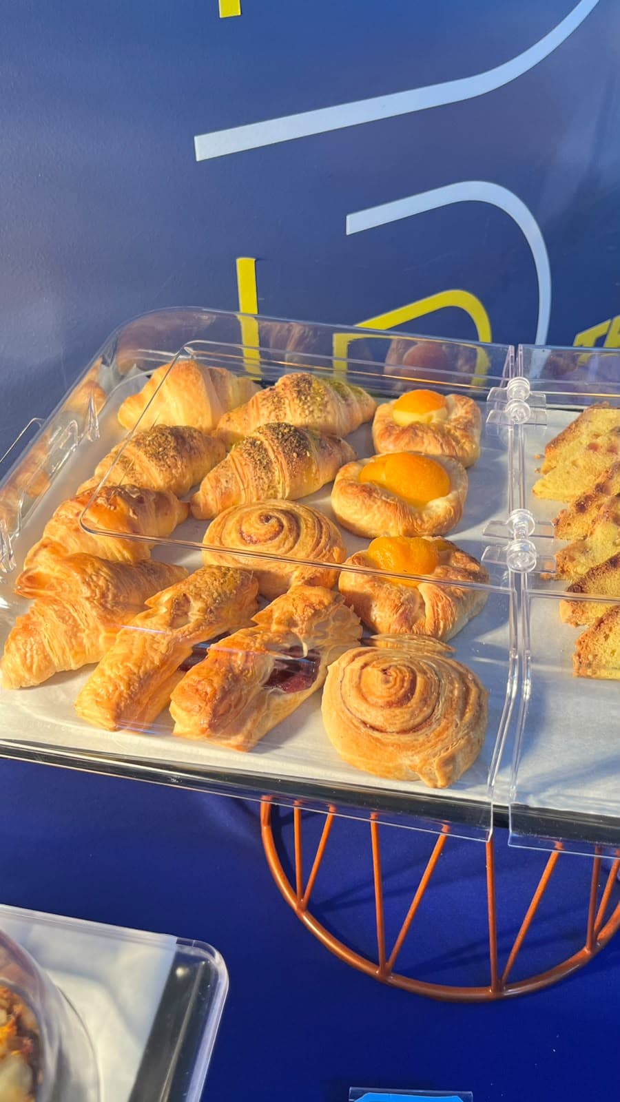 Butter croissants and cinnamon rolls under a buffet dome