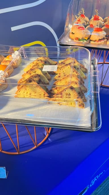 Triangle sandwiches and pastries on a buffet stand in Doha