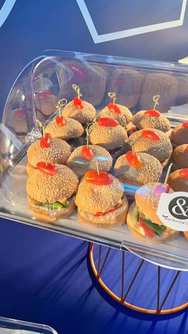 Mini burgers topped with cherry tomatoes on a corporate catering buffet in Doha