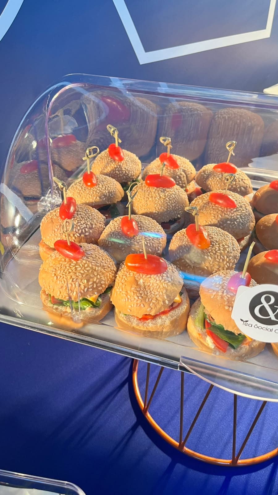 Mini burgers topped with cherry tomatoes on a corporate catering buffet in Doha